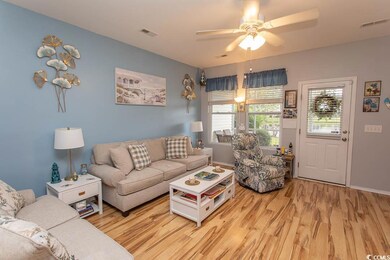 Living room featuring light wood-style flooring and ceiling fan