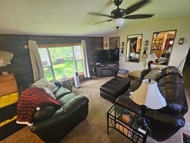 Living room featuring ceiling fan, vaulted ceiling