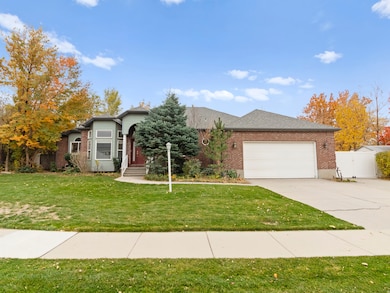 View of front of house with brick siding, concrete driveway, a garage, and a gate