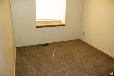 Unfurnished room featuring baseboards, visible vents, and carpet floors