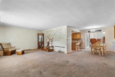 Living room featuring light colored carpet and a chandelier
