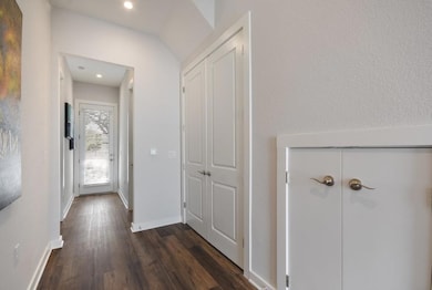 Corridor with dark wood-style flooring, baseboard