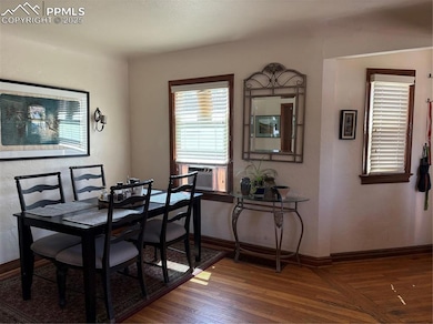 Dining room with dark wood-style floors, a textured wall, and cooling unit