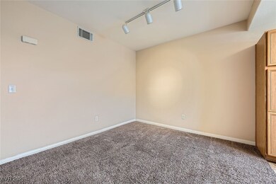 Empty room with track lighting, carpet flooring, a