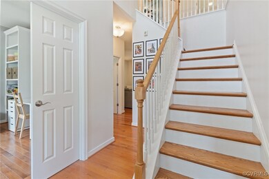Stairway with wood finished floors, baseboards, an
