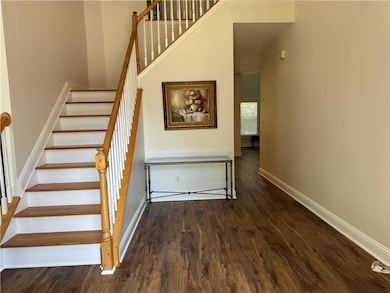 Stairway featuring wood finished floors, baseboards, and a high ceiling