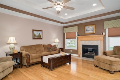 This great room has a trey ceiling, fan, and lots 