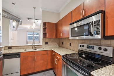 Kitchen with kitchen peninsula, crown molding, sin