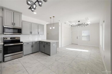 Kitchen featuring a chandelier, gray cabinetry, appliances with stainless steel finishes, light marble finish floors, and recessed lighting
