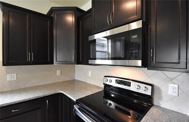 Designer Kitchen with Espresso Cabinets, Granite Countertops, Tile Backsplash, and Stainless Steel Appliances