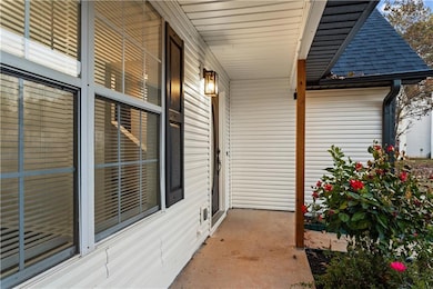 Doorway to property featuring a porch and roof with shingles