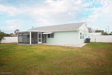 Rear view of property with a lawn, a sunroom, and