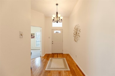 Entryway with an inviting chandelier and light wood-type flooring