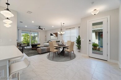 Tiled dining area featuring ceiling fan with notable chandelier and a healthy amount of sunlight. Virtual Staging