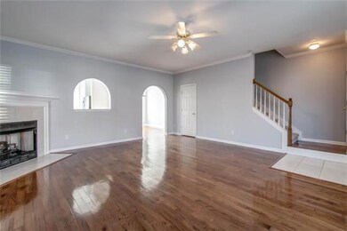Spacious living room featuring hardwood floors, bay window, and fire place. 