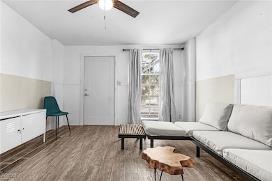 Living area with wood finished floors and a ceiling fan