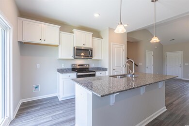 Kitchen with sink, white cabinetry, appliances wit