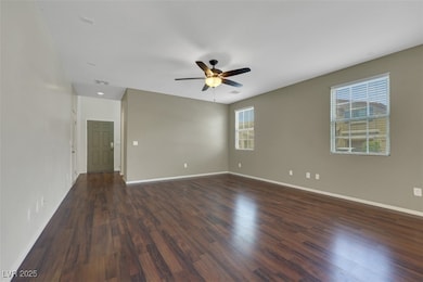 Empty room featuring ceiling fan and dark wood-sty