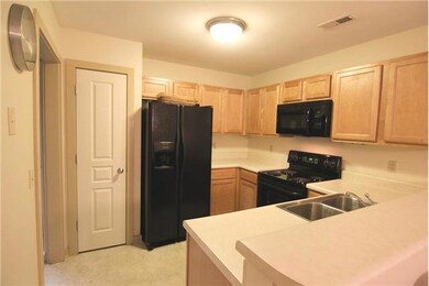 Kitchen with plenty of storage space in the maple cabinets and full closet pantry. All appliances remain including the refigerator, stove, microwave, dishwasher, and disposal. The eat-in breakfast bar countertop looks out to the adjacent dining room.
