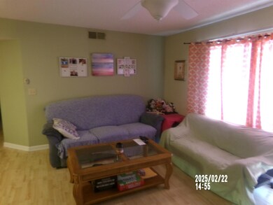 Living room featuring visible vents, ceiling fan, 