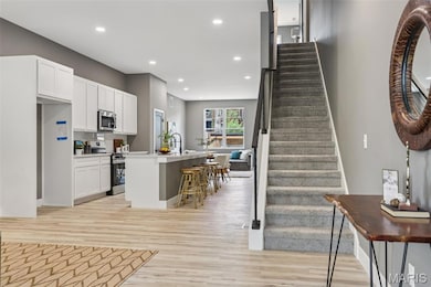 Stairs featuring wood finished floors and recessed lighting