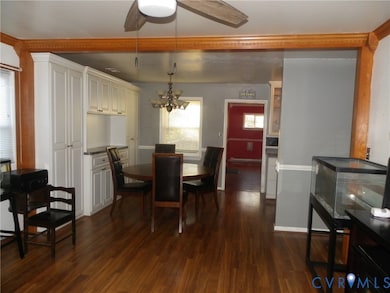 Dining room featuring dark wood-style floors, a ceiling fan, and a chandelier