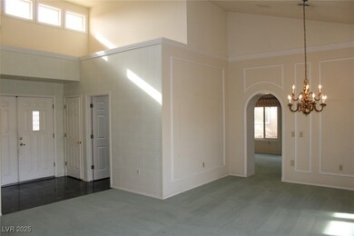 Foyer featuring arched walkways, carpet, high vaul