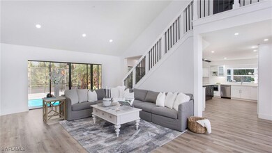 Living room with high vaulted ceiling, recessed li