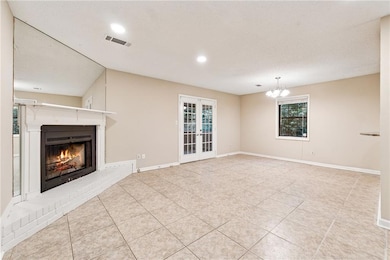 Unfurnished living room featuring a fireplace, french doors, tile patterned floors, recessed lighting, and plenty of natural light