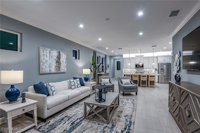 Living room with crown molding, light tile patterned floors, and recessed lighting