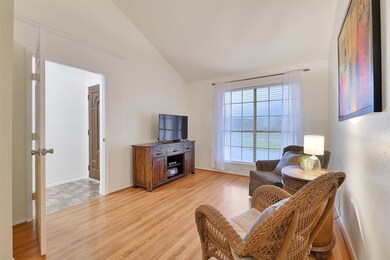 Just off of the left side of the foyer, this flexible-use space could serve as a dining room, a study, a playroom, or a 4th bedroom. It features a soaring vaulted ceiling with a lighted ceiling fan, a front-facing window, and a door for direct access to the kitchen.