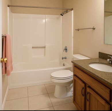 Bathroom featuring vanity, light tile patterned floors, and bathing tub / shower combination