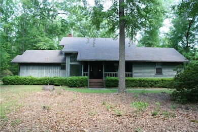 View of front of home with a chimney, roof with sh