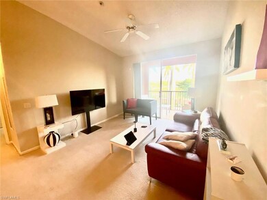 Carpeted living area featuring ceiling fan, baseboards, and vaulted ceiling