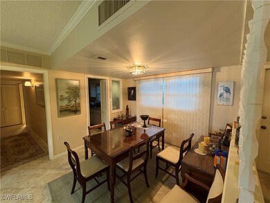 Dining room with a textured ceiling and ornamental molding