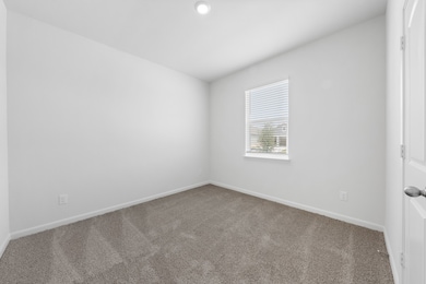 Empty room with carpet flooring and baseboards