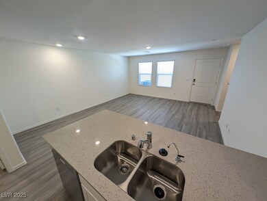 Kitchen featuring a sink, wood finished floors, li