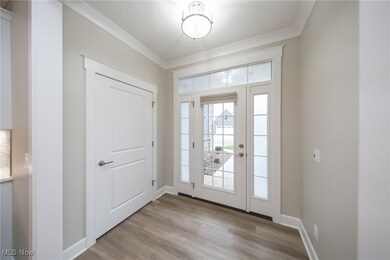 Foyer featuring light wood-type flooring and crown molding