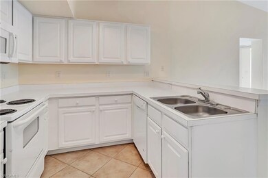 Kitchen featuring white cabinets, light tile patte