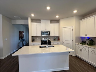 Kitchen featuring stainless steel appliances, dark