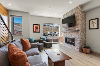 Living area featuring light wood-style flooring, a fireplace, and recessed lighting