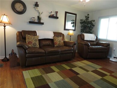 The living room is warm and inviting with hard woo