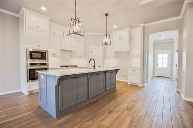 Kitchen with a center island with sink, stainless 