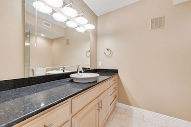 Bathroom with tile patterned floors, vanity, and v
