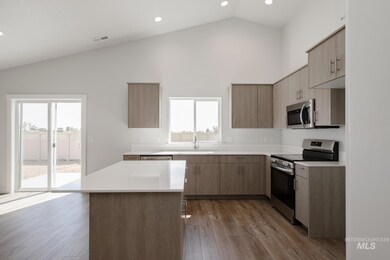 Kitchen with stainless steel appliances, modern cabinets, dark wood-style flooring, recessed lighting, and high vaulted ceiling