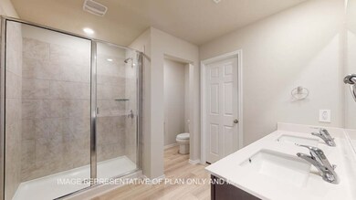 Bathroom with double vanity, a stall shower, and light wood finished floors