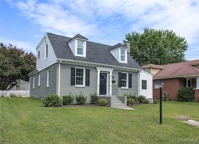 New england style home featuring a front lawn