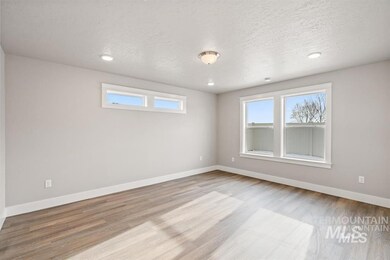 Empty room with wood finished floors, a textured ceiling, and recessed lighting
