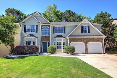 View of front of property featuring concrete driveway, a front lawn, and stone siding