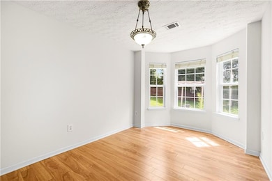 Unfurnished dining area featuring light wood finished floors and baseboards